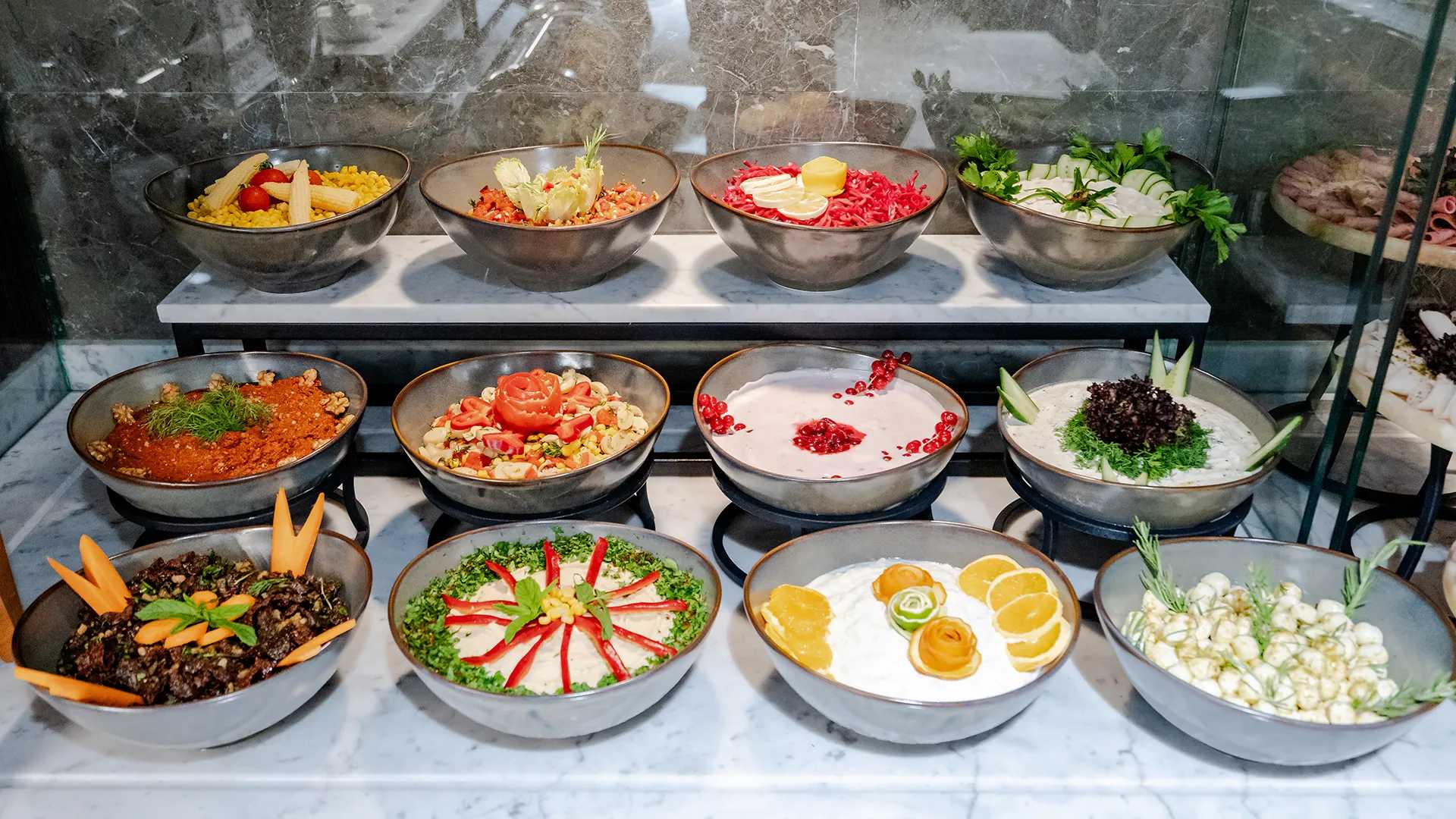 Forskellige skåle med mad er udstillet i en morgenmadsbuffet.
