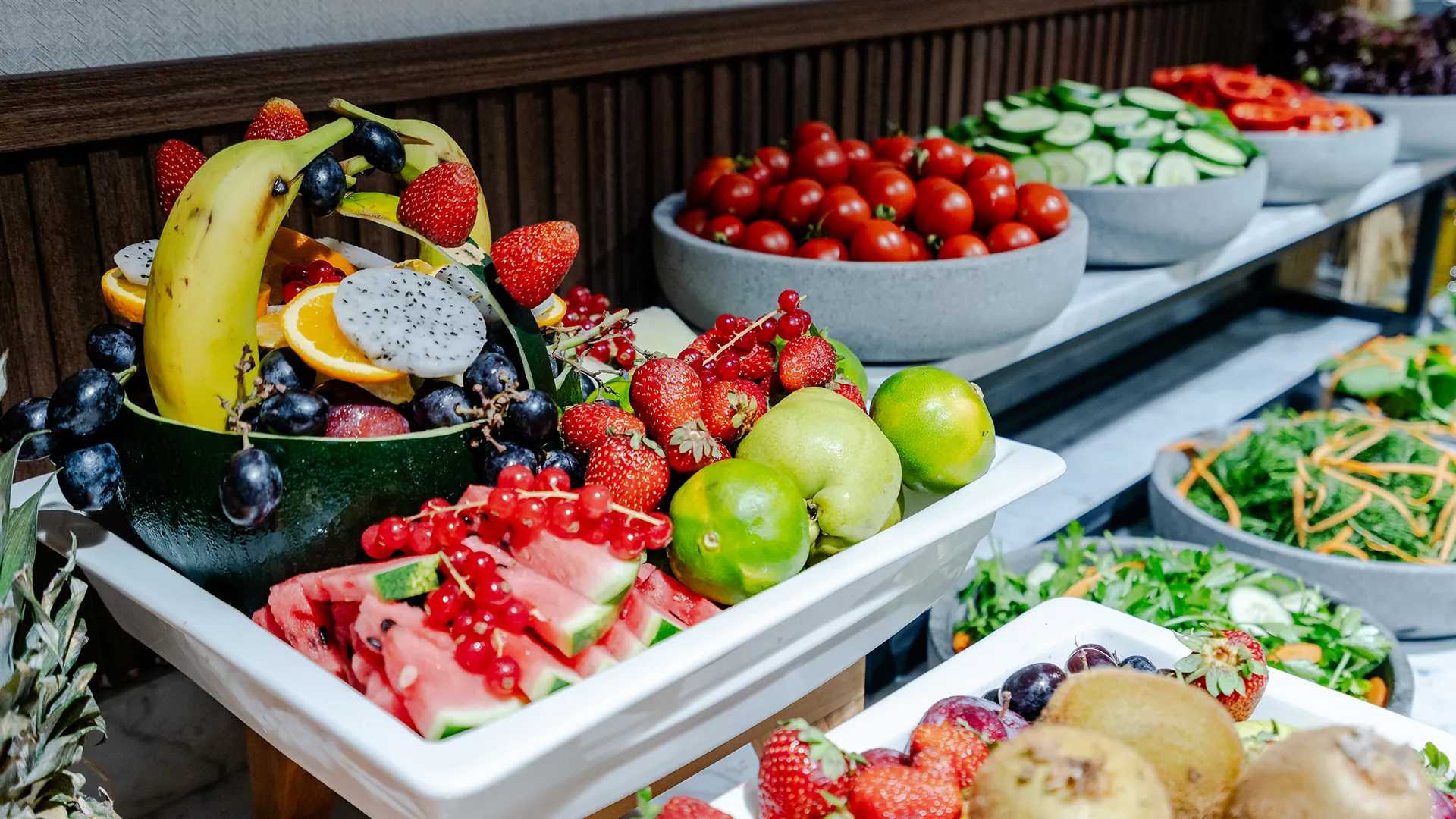 Um buffet de café da manhã com uma variedade de frutas, incluindo morangos.